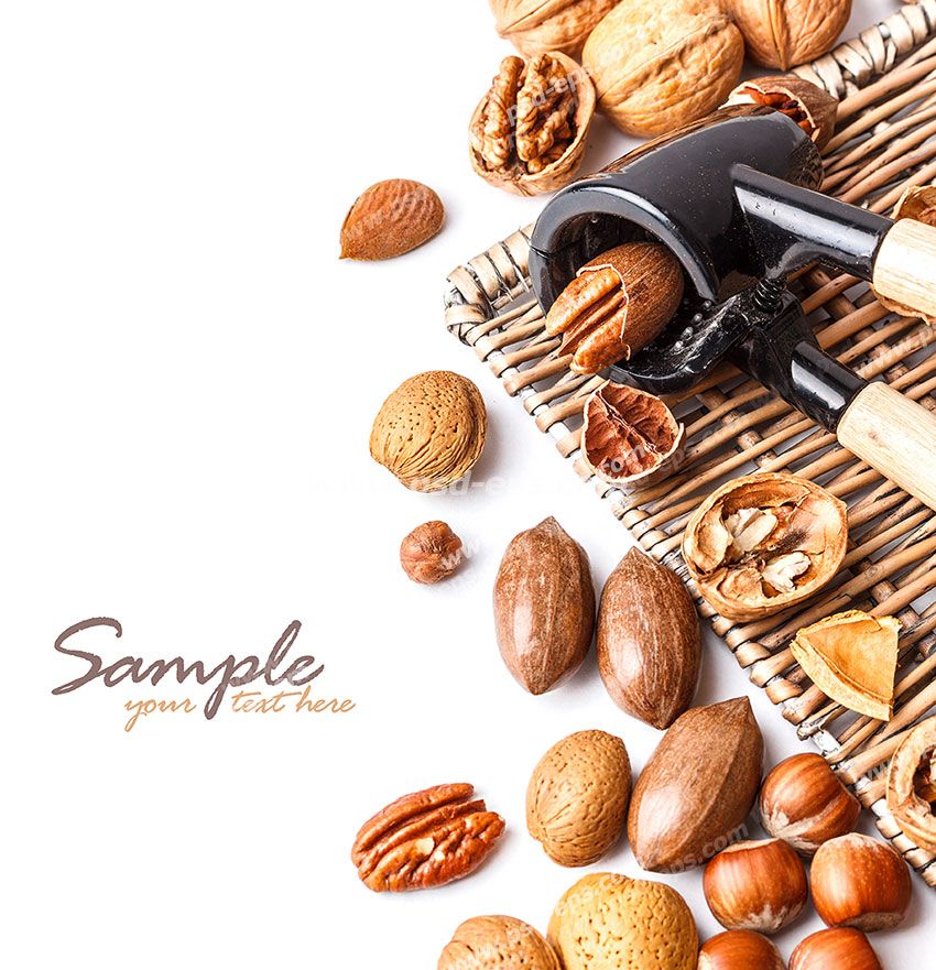 عکس با کیفیت دستگاه دستی گردو شکن به همراه آجیل های مختلف اعم از گردو ، فندق و بادام در کنار آن